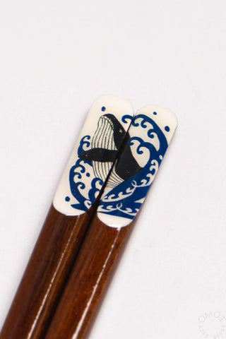 Chopsticks with whale and wave design on a white background