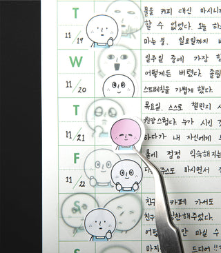 Calendar with cartoon character stickers and tweezers placing a sticker