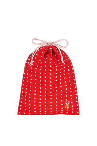 Red drawstring bag with white polka dots and gold bell in the corner on a white background