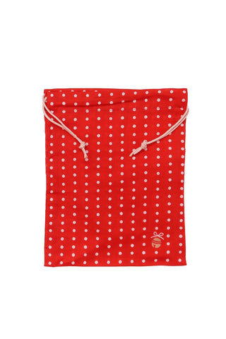 Red drawstring bag with white polka dots and gold bell in the corner on a white background