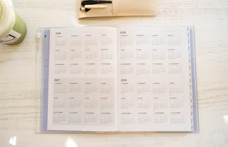 Opened planner page showing year plan for 2026-2029 on a light table