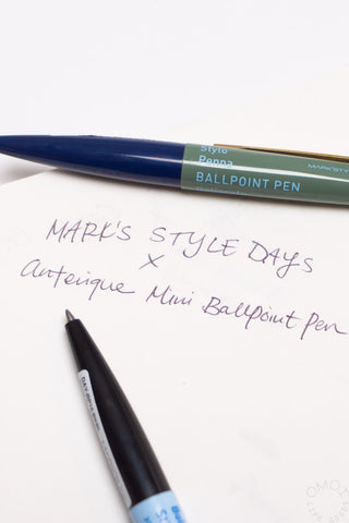 Two Marks mini pens with handwritten text on a white notebook