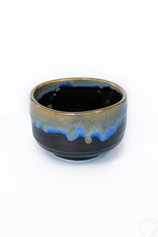 Ceramic matcha chawan with blue interior and rim on a white background