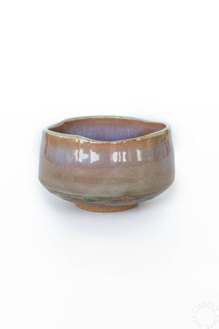 Ceramic bowl with a brown and purple glaze on a white background