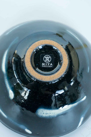 Close-up of the bottom of a matcha chawan with a brown bottom and 'MIYA' branding on a white background.