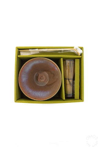 Ceramic bowl with scoop and whisk in a green box on a white background
