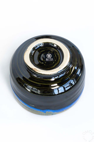 Bottom of ceramic bowl with white rim on a white background