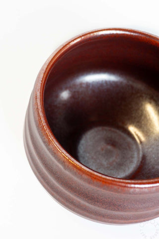 Close-up of a brown ceramic bowl on a white background