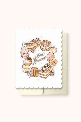 Greeting card with illustrations of pastries and the text 'Merci Beaucoup' on a white background.