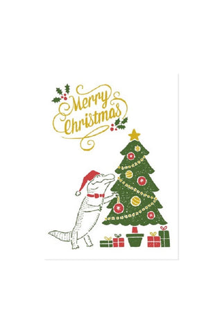 Illustration of a crocodile decorating a Christmas tree with 'Merry Christmas' text above.