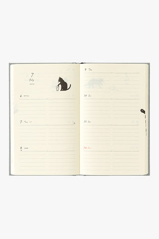 Open notebook with lined pages and a small illustration of a cat on a white background