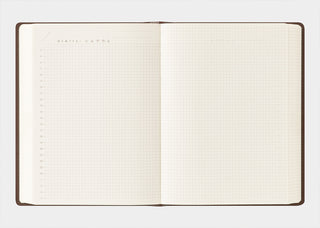 Opened brown diary with grid pages