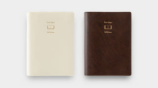 Two hibino diaries next to each other, one ivory one brown