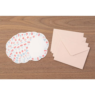 Stationery set with letterpress sheets and matching envelopes on a wooden table