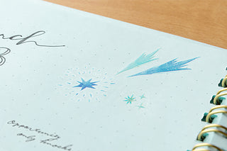 Notebook page with star sticker illustrations on a wooden surface