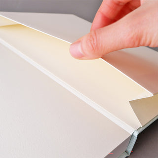 A close-up of a hand opening small storage space in notebook for small items