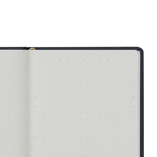 Close-up of an open notebook with light gray dot grid pages