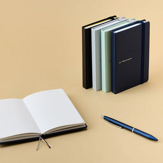 Set of notebooks and a pen on a beige background