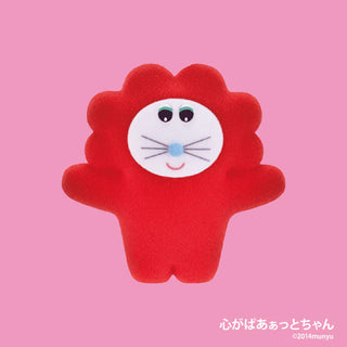 Red plush toy with a white face on a pink background