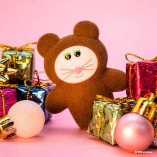 Brown teddy bear toy with colorful gift boxes and ornaments on a pink background