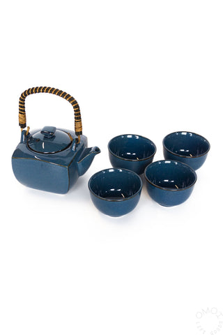 Blue ceramic teapot with four matching cups on a white background