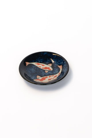 Ceramic dish with koi fish design on a white background