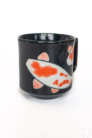 Dark blue mug with a red and white fish design on a white background
