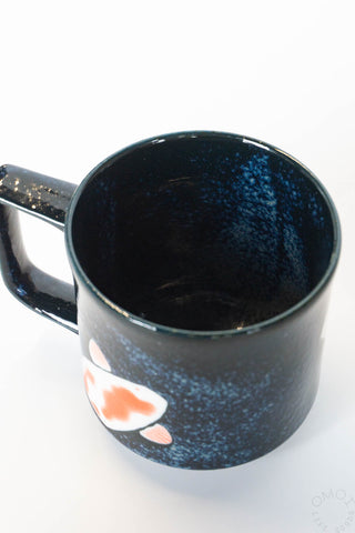Blue speckled mug with a small design on a white background