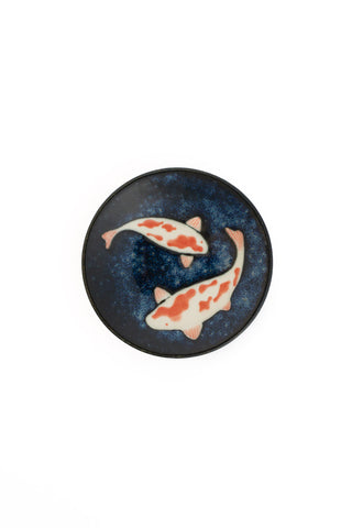 Decorative plate with koi fish design on a dark blue background