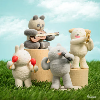 Toy figures of animals playing instruments on grass with a blue sky background