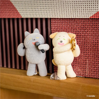 Two animal plush toys, one gray and one white, standing on a wooden surface with a textured red and white background.