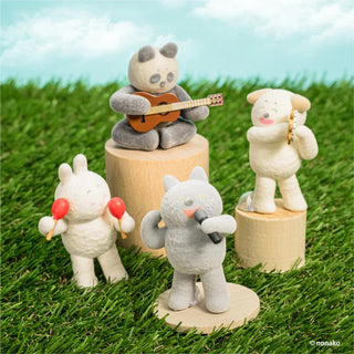 Toy figures of animals playing musical instruments on grass with a blue sky background