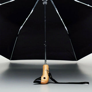 Black umbrella with a wooden handle on a gray background