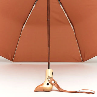 Close up of opened mocha color umbrella with wooden duck head handle