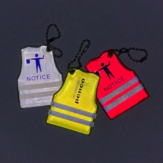 reflective safety vest keychains in white, yellow, and red, arranged on a dark gray background. Features a chain and a 'NOTICE' graphic with a worker icon.