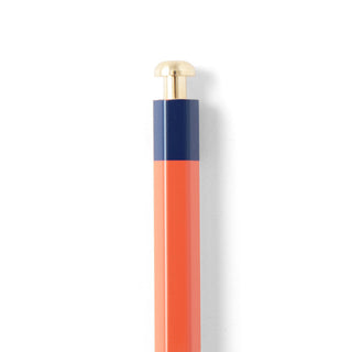 Pencil with orange body showing gold tip on a white background