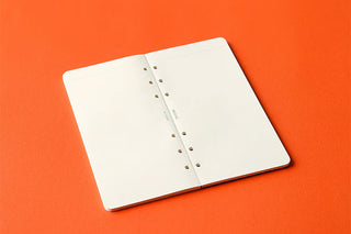 Open notebook with ring binding on an orange background