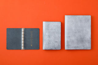 Three binders of different sizes on an orange background