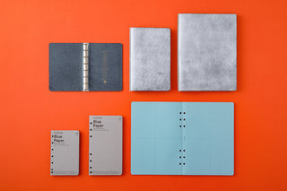 Set of binders and notebooks in various sizes on an orange background