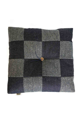 Checkered cushion with black, gray, and blue squares on a white background