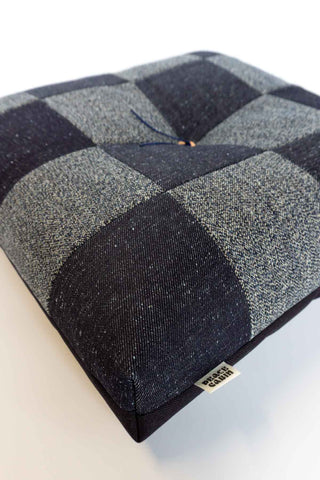 Checkered cushion with a brand label on a white background