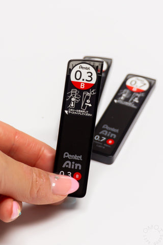 Pentel Ain lead refill with a hand holding it on a white background