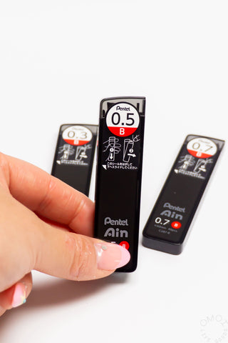 Pentel Ain lead refill with a hand holding it on a white background