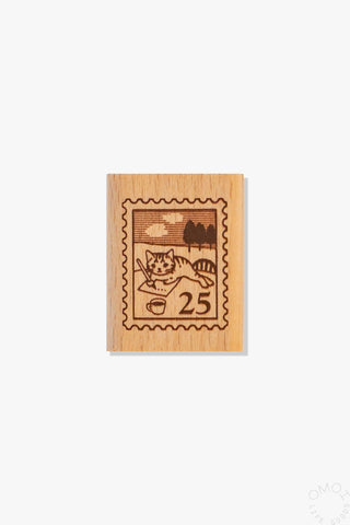 Wooden stamp with a design of a postage stamp with a cat and number 25 on a white background