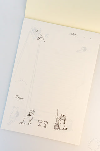Memo pad page with illustration of a cat opening champagne bottle and the cork flying away