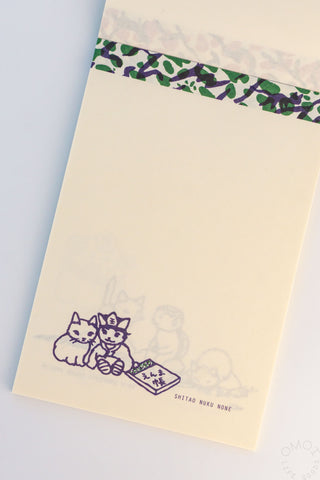 Beige paper with cat design and green border on a light gray background