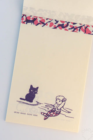 Memo pad with black cat and mermaid design on a light blue background