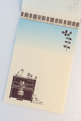 Memo pad pages with cats around a piano and Matryoshka dolls