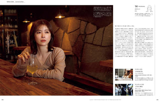 Magazine page with a woman seated at a bar holding a drink, with article text
