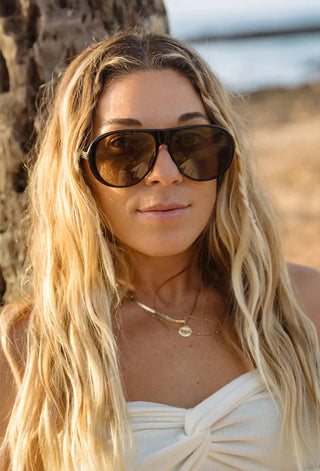 Black sunglasses with brown lenses on a woman with long blonde hair